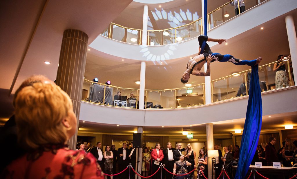 Acrobat swinging off silk. Photograph by midlands Commercial Photographer Ben Roberts, Blooming Photography.