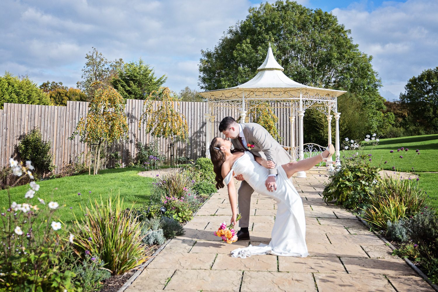Bride and groom doing a dip in The Pear Tree, Purton. Candid wedding photo for Wiltshire Wedding.