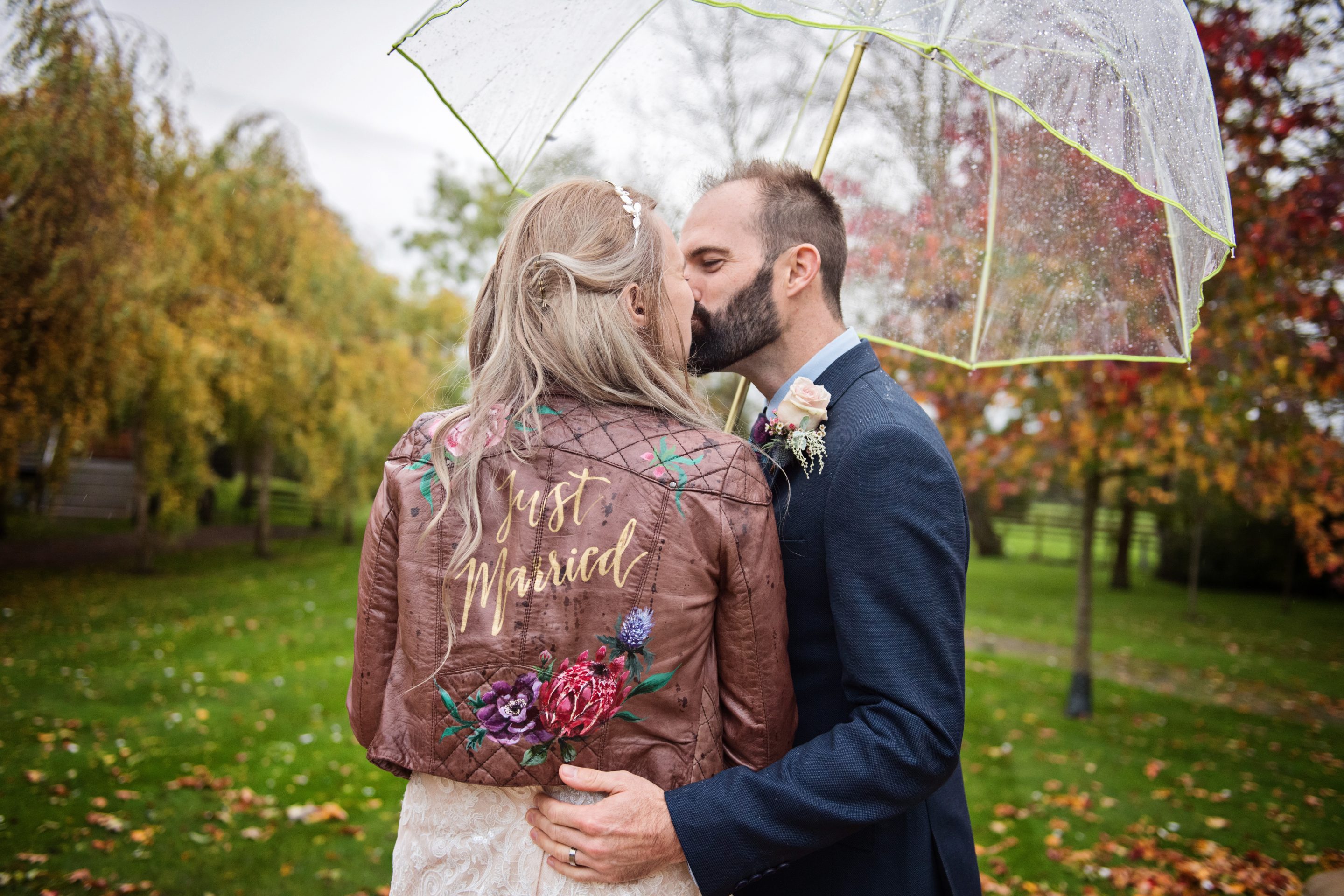 Bride and groom kiss under an umbrella. 