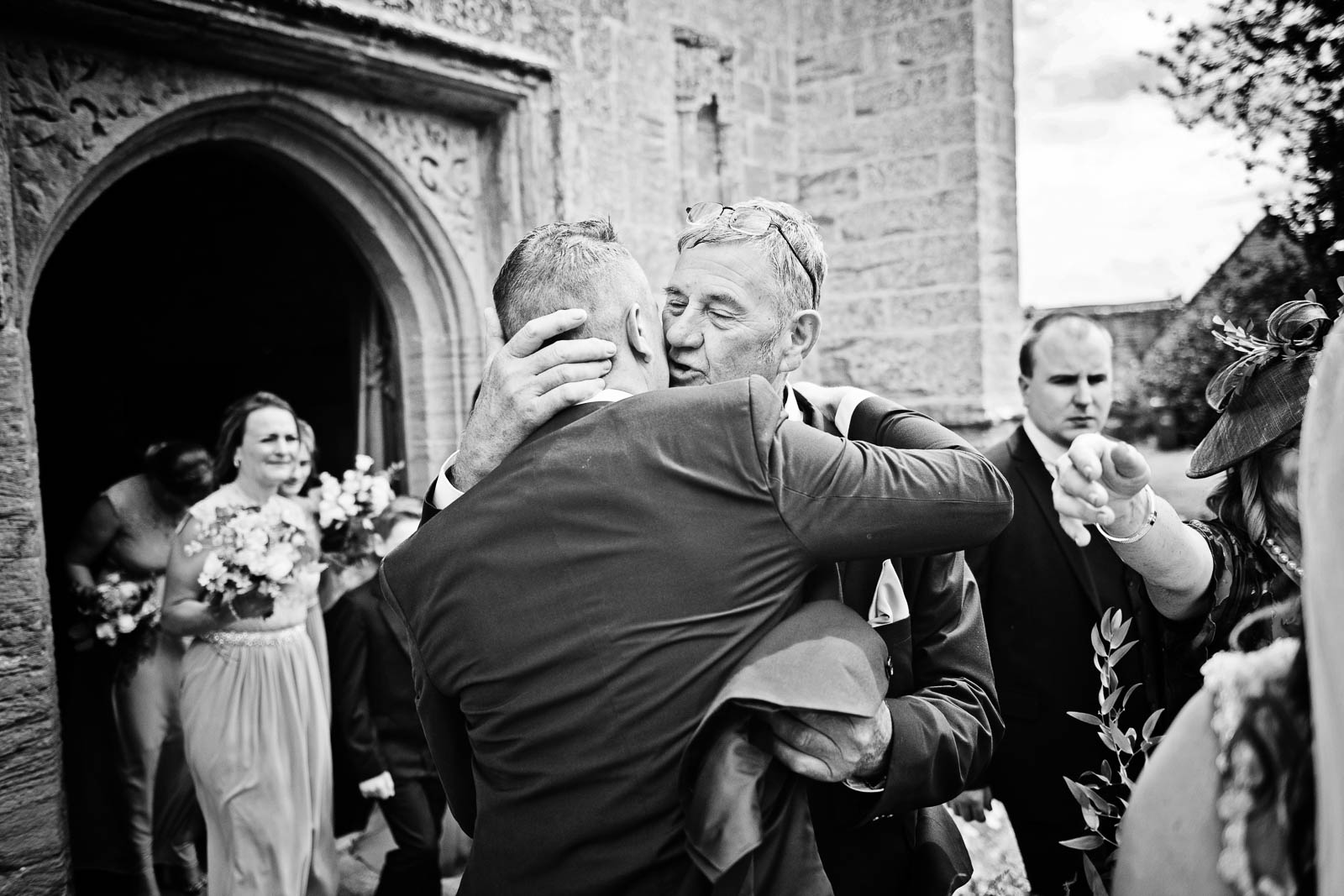 Groom getting hugged by a wedding guest